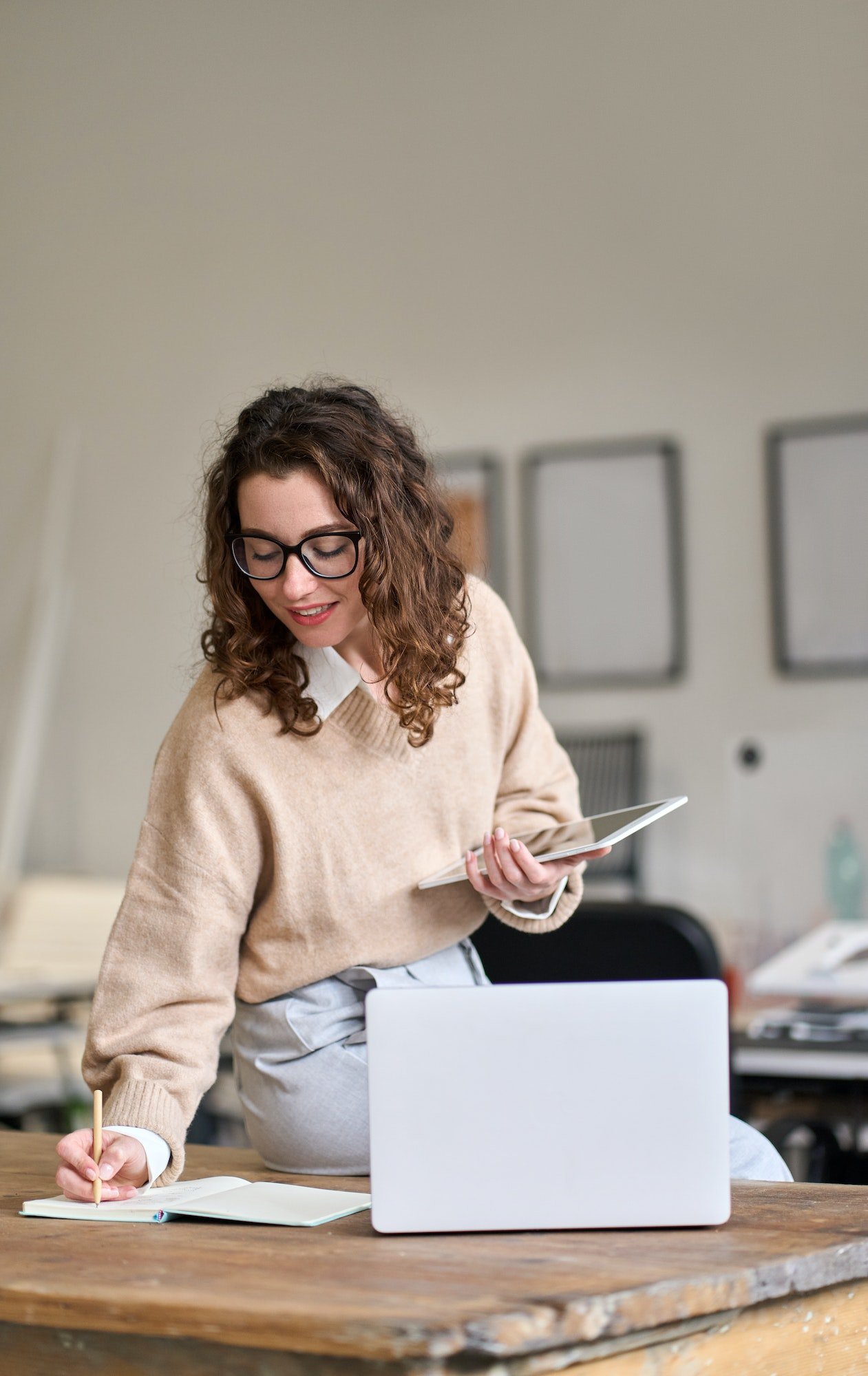 young-smiling-business-woman-working-in-office-using-digital-tablet-vertical.jpg